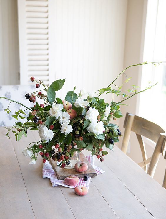 a fresh summer centerpiece or arrangement with white blooms, peaches and berries is a beautiful idea