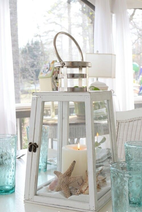 a large candle lantern with beach sand, starfish and seashells plus a large candle to decorate indoors or outdoors