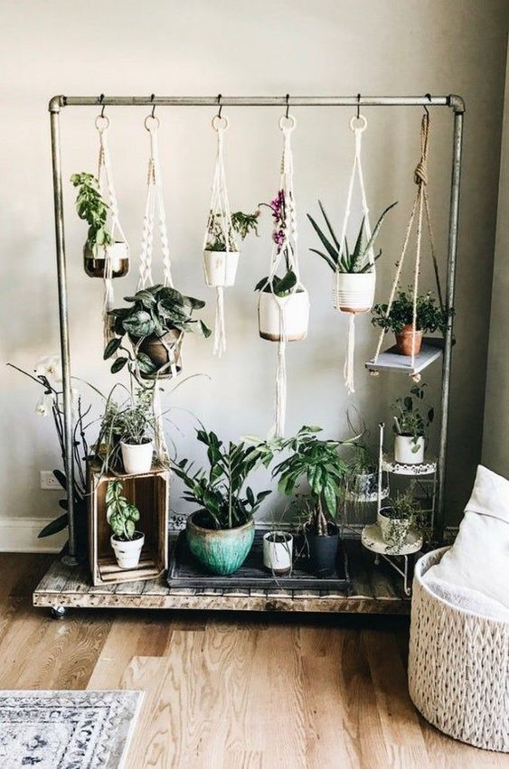 a metal and wood stand with lots of hanging planters with flowers and succulents is a very stylish idea