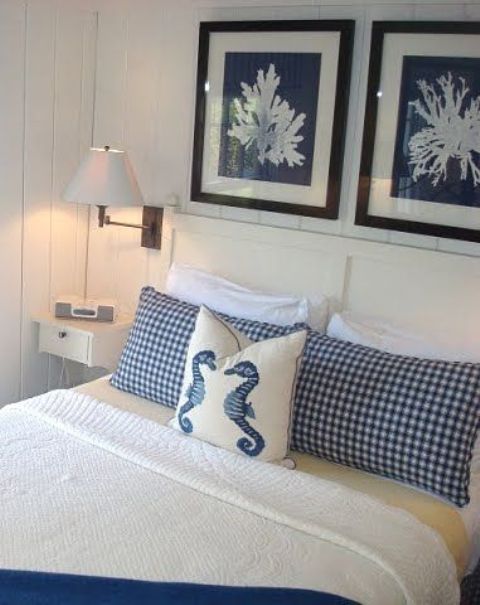 a nautical bedroom with coral artworks, nautical bedding and simple white furniture is a very fresh and cool idea to rock