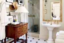 a neutral bathroom with black and white tile floor, a vintage dresser, a free-standing sink, a gallery wall and a couple of mirrors