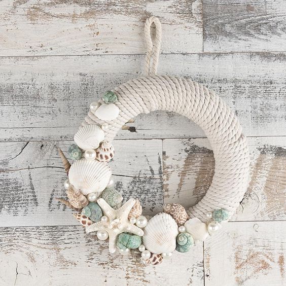 a pretty rope wreath with starfish, seashells and various pearls looks very coastal or beachy