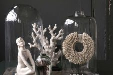 a refined decor composition of corals, a statuette, some creative decorations in cloches is a lovely idea for a sophisticated space