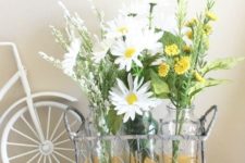 a wire basket with bottles and white and yellow blooms is a chic and simple rustic decoration