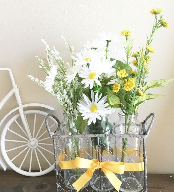 a wire basket with bottles and white and yellow blooms is a chic and simple rustic decoration