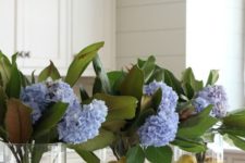 clear vases with citrus and blue hydrangeas and magnolia leaves for chic traditional southern decor