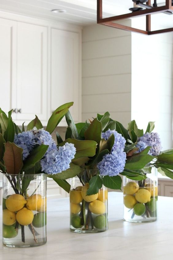 clear vases with citrus and blue hydrangeas and magnolia leaves for chic traditional southern decor