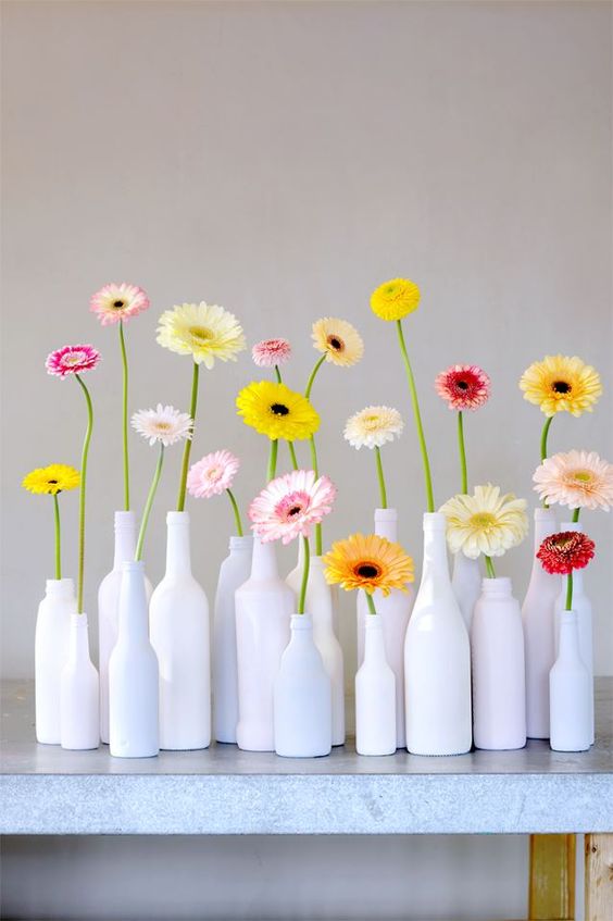 white bottles with colorful gerberas for a modern and bold summer decoration that is easy to compose