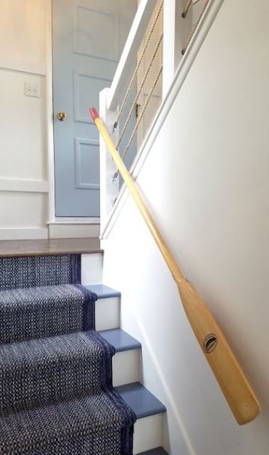 a beach staircase in blue and white covered with a navy carpet and with rope and oar railings is amazing