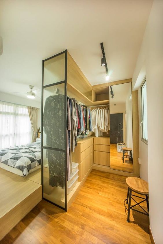 a bedroom with a walk-in closet is a fantastic idea, you can make a sleeping space on a platform and a closet with a large mirror and sleek drawers