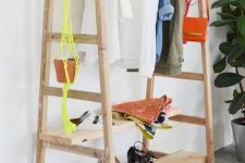 a comfy clothes and shoe rack made of a couple of ladders and some wooden planks, easy to DIY and very functional