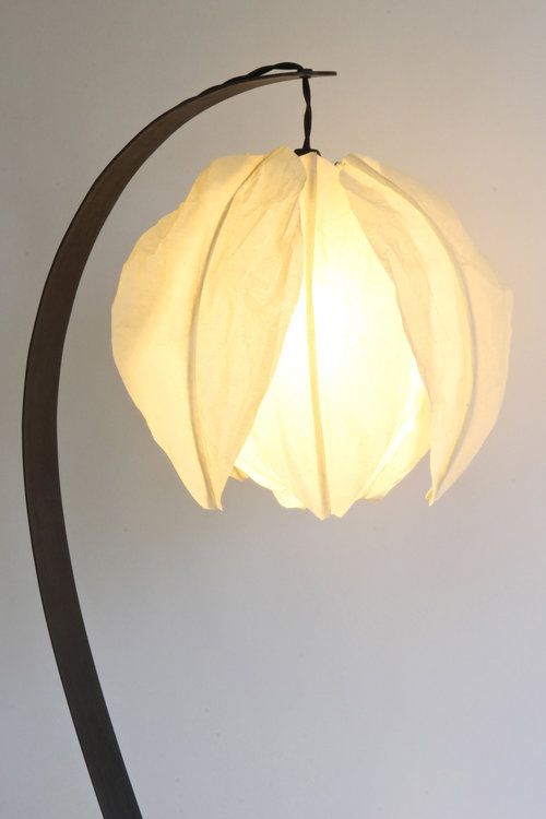 A curved table lamp with a flower shaped lampshade looks very pretty and very chic