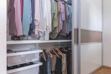 a large closet with glass sliding doors and lots of shelves, baskets and drawers is a stylish idea for any bedroom and it gives a lot of storage
