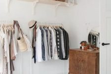 a makeshift closet in a serene bedroom takes one wall and there’s much storage space
