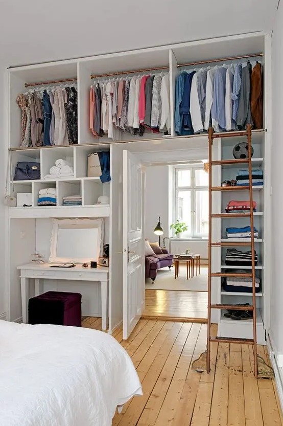 a makeshift closet placed over the doorway and the vanity space, with open shelves is a perfect way to save space in a tiny bedroom