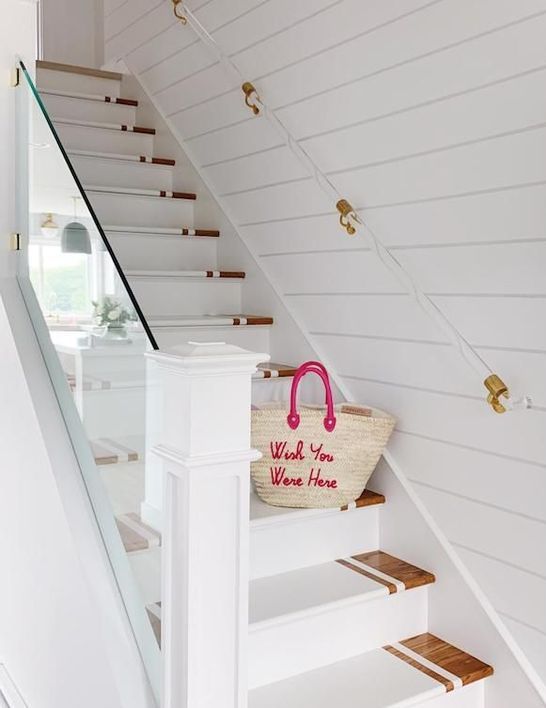 a modern beach staircase with stained and white painted steps, acrylic and gold railing and clear railing is amazing