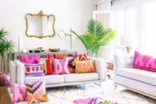 a neutral living room infused with bold printed pillows and tropical plants in pots for a summer feel
