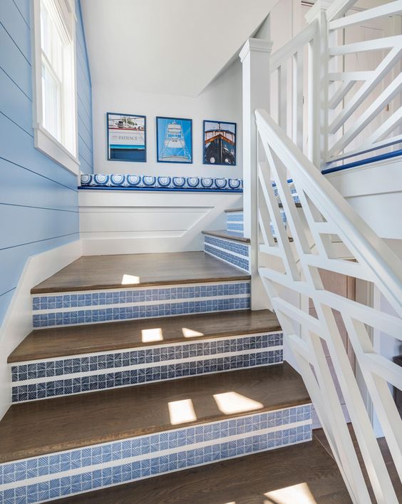 a pretty seaside staircase with stained steps and blue striped risers is a chic idea for a coastal home