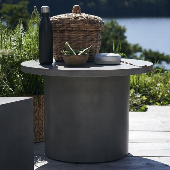 a round concrete table and a matching stool are a lovely idea for a contemporary or minimalist outdoor space