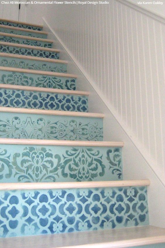 a seaside staircase with risers paitned light blue and stenciled with various patterns in navy shades