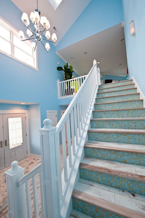 a seaside staircase with tiled steps and blue mosaic tile risers feels Mediterranean and looks beautiful