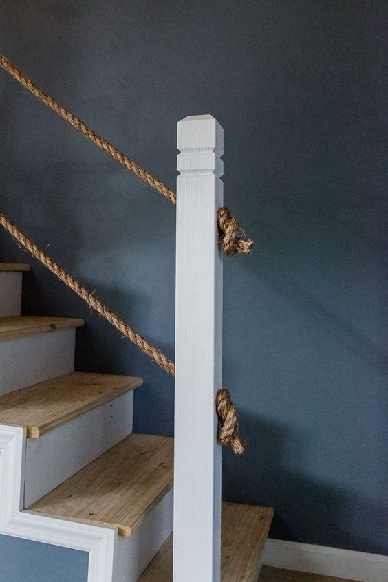 a simple and casual staircase with stained steps and rope railing is a cool and chic idea to rock