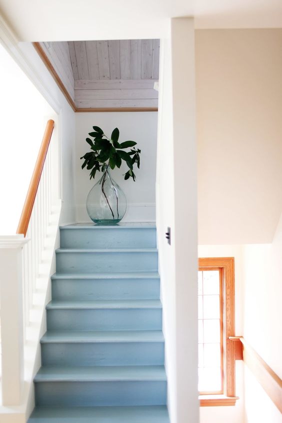 a subtle light blue staircase with white railing feels seaside, coastal or beach-like and will fit any of such houses