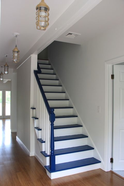 a very simple nautical staircase in navy and white is a bold and contrasting solution to rock in your seaside home