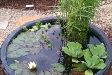 a wooden barrel with water lilies and greenery is a cool rustic idea for outdoor decor is easy to compose