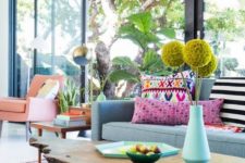 bright yellow blooms, printed colorful pillows, a bright boho rug make the living room feel like summer