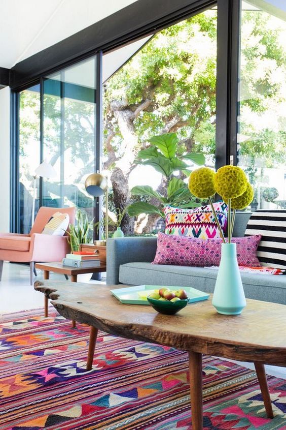 bright yellow blooms, printed colorful pillows, a bright boho rug make the living room feel like summer