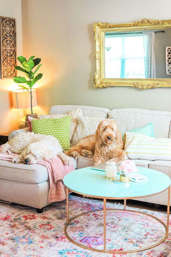 pastel pillows and blankets, a floral print rug, a turquoise table and pillows for a fun and bold living room