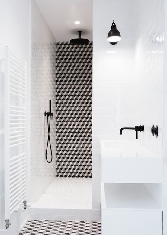 A bold black and white bathroom with geo tiles and black fixtures looks ultra modern and very chic
