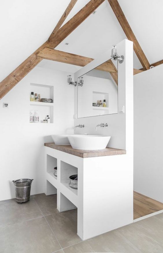 a contemporary white attic bathroom with wooden beams and countertops plus built-in storage spaces