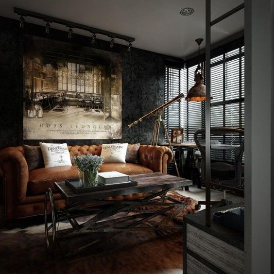a dark industrial room with a leather sofa, a wood and metal table, a vintage metal pendant lamp and a fur rug