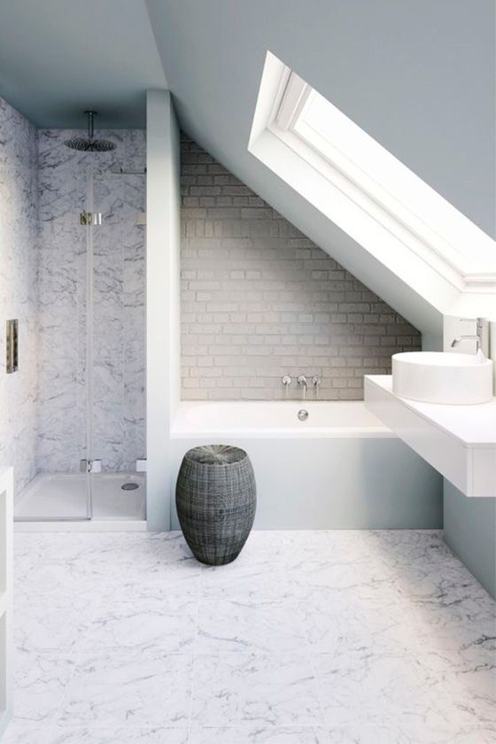 a neutral attic bathroom with marble tiles, faux brick, a basket for storage and a skylight and a floating vanity