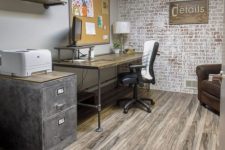a simple rustic industrial home office with a desk that changes height, leather chairs, a metal cabinet