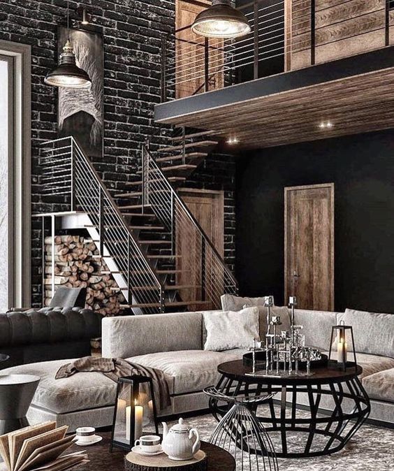 an industrial feel is achieved with black brick walls, a black metal table, lanterns and firewood storage under the stairs