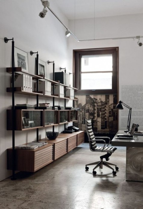 an industrial home office with a stone and wood desk, a large shelving unit or metal and wood and some vintage metal lamps