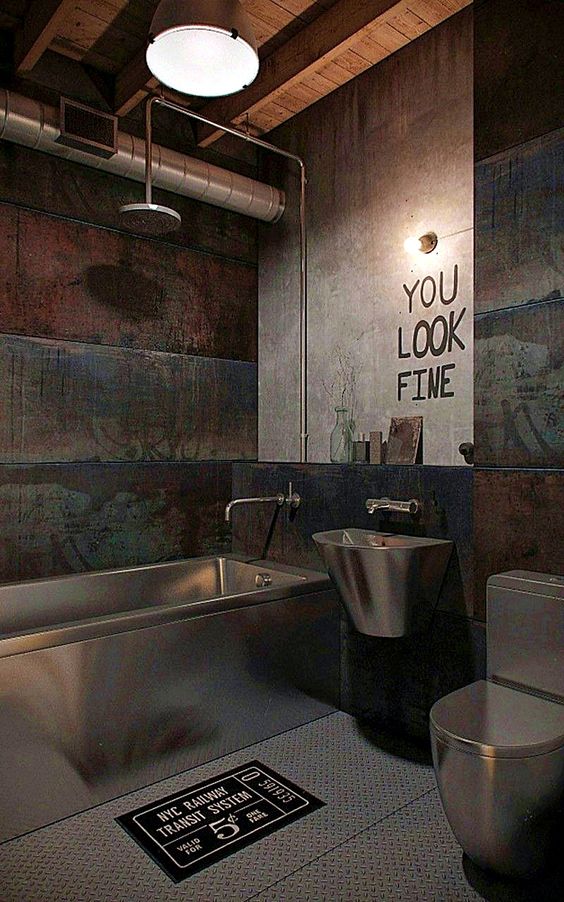 an industrial modern bathroom with concrete and rough wood walls, exposed pipes, lights and metal appliances