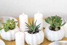 Nordic fall table decor with white pumpkin planters with succulents, pillar candles and a mustard tablecloth