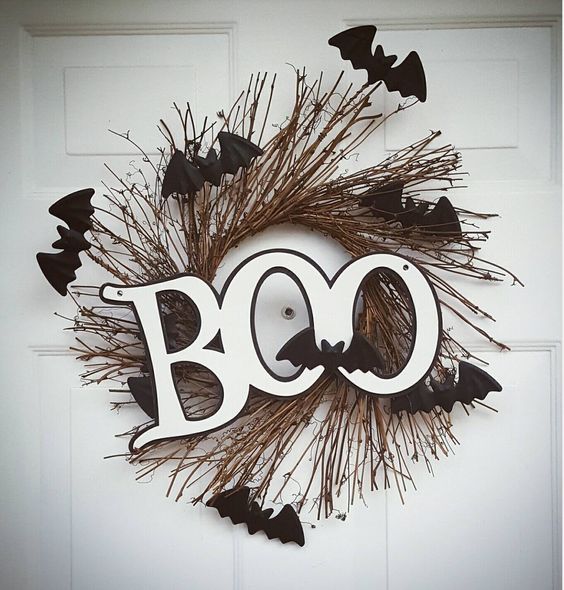 a Halloween twig wreath with black bats and black and white letters is a small and cool idea to decorate your front door in a creative way