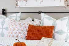 a bold orange pillow, a plaid blanket and a fabric pumpkin in a basket for a fall touch in the living room