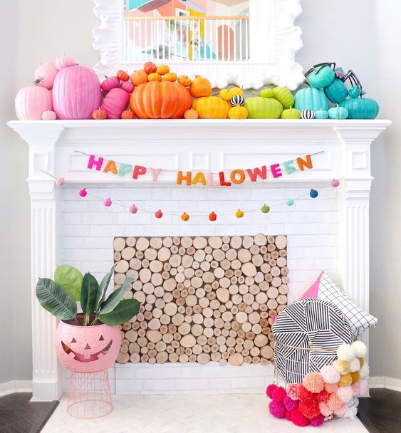 a bright Halloween mantel with bold rainbow pumpkins, a mini pumpkin garland, yarn letters and a pompom basket