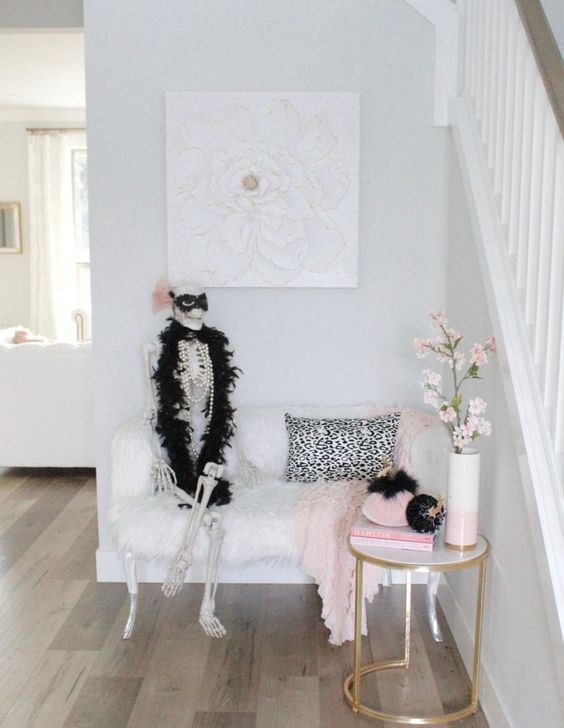 a glam Halloween entryway with a skeleton in pearls and fur, pink and black velvet pumpkins
