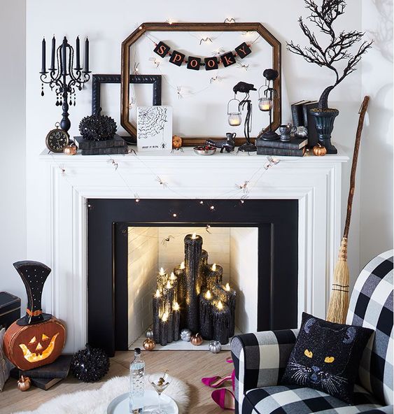 a glam Halloween fireplace with black glitter candles, a spooky tree, a banner, crows, a rhinestone pumpkin, cat pillows and lights