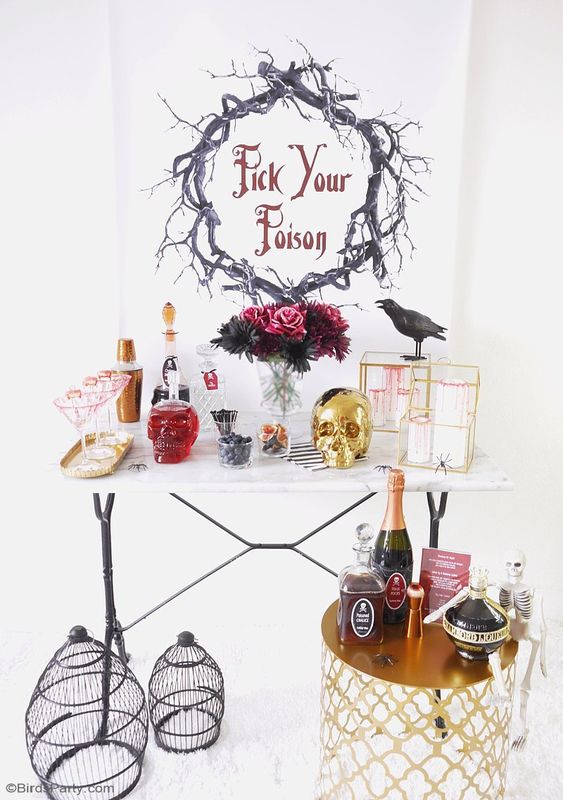 a glam cocktail nook with a gold skull, a crow, a bold floral arrangement, cages and a gold mini table