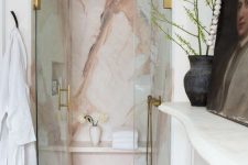 a gorgeous pink marble shower space wiht glass doors and elegant copper fixtures is a lovely idea that looks super refined