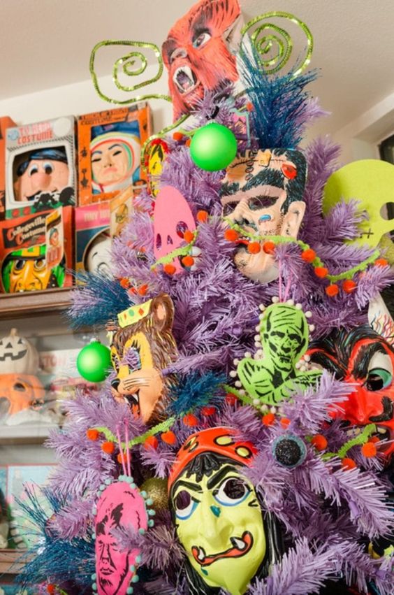 a lilac Halloween tree decorated with non green, yellow and pink monster decor and masks is wow
