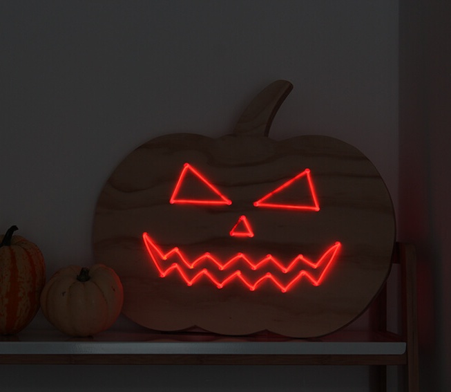 a plywood pumpkin decorated with red neon is a fantastic alternative to carving it